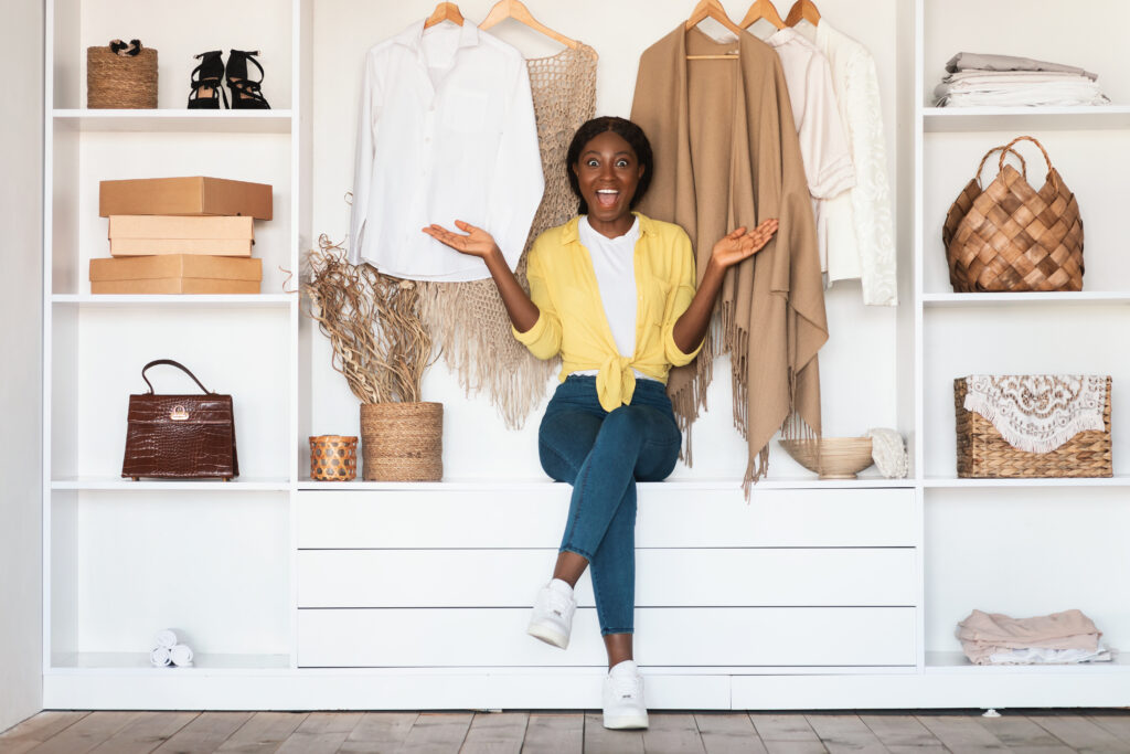 Excited African American Lady Posing In Wardrobe Among Clothes