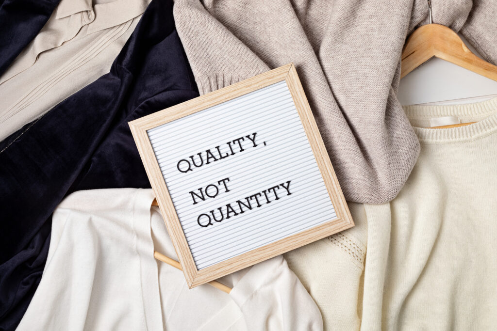 Flat lay of clothes and hangers; assortment of women's clothing. Second hand sustainable shopping; capsule minimal wardrobe; slow fashion idea; quality not quantity concept